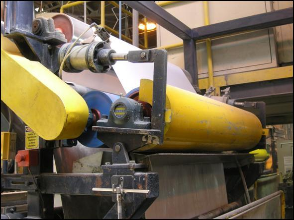 A sheet of material passing over rollers on a manufacturing line.